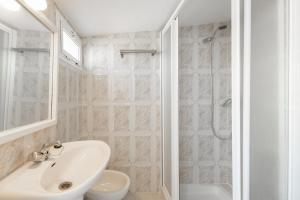 un bagno bianco con lavandino e doccia di La casita de Tereses a Guadalcanal Altre 25 foto