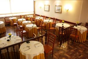 a restaurant with tables and chairs with white tablecloths at Hotel Vice-Rei in Porto