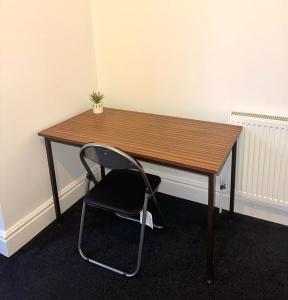 a wooden desk with a chair in a room at Large 2 bed apt in Peterborough city centre in Peterborough