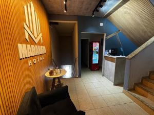 a hallway with a table and a soda machine at Maranata Hotel in Aparecida