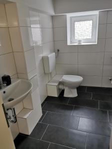 a bathroom with a toilet and a sink and a window at 1-Zimmer Wohnung in Herne