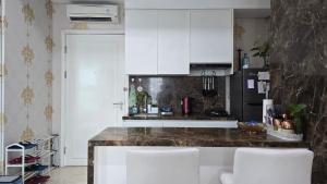 a kitchen with white cabinets and a counter top at AYTE Capitol Suites - Central Jakarta City Centre in Jakarta