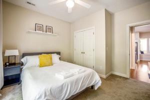 a bedroom with a white bed with a yellow pillow at The Clubhouse in Southern Pines