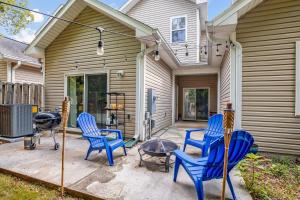 a patio with blue chairs and a table and a grill at The Clubhouse in Southern Pines