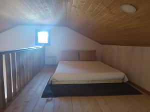 Bett in einem kleinen Zimmer mit Holzdecke in der Unterkunft Casa tapada da branda in Monção