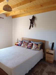 ein Schlafzimmer mit einem weißen Bett mit Kissen darauf in der Unterkunft Casa tapada da branda in Monção