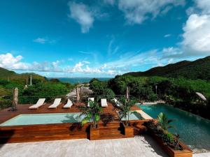 a pool with a deck and chairs next to the water at Duplex de luxe avec piscine privée, cuisine équipée et Wi-Fi à Anse Marcel - FR-1-734-63 in Marigot