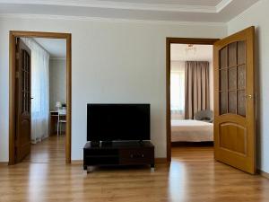 a living room with a television and a bedroom at Center two bedroom apartment in Daugavpils