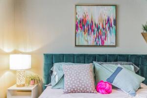 a bedroom with a bed with a green head board at Vibrant 2bed Condo - Stroll to SEA Space Needle in Seattle