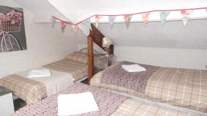 a room with three beds and flags on the ceiling at Tynedale Guest House in Penrith