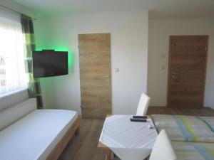a room with a bed and a table and a television at Frühstückspension Kibler in Sankt Georgen im Attergau