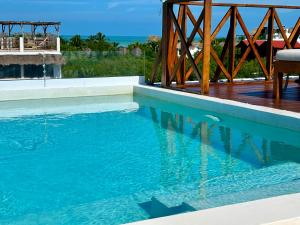 ein Schwimmbecken mit blauem Wasser und eine Holzbrücke in der Unterkunft sunsteps casa holbox in Holbox