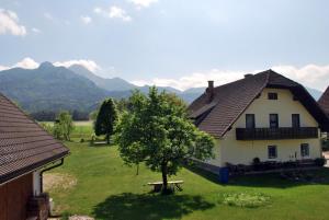 una casa blanca con un árbol en el patio en Ferienhof Ressmann-Tratnik en Ledenitzen