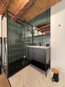 a bathroom with a sink and green tiled walls at Spacieuse et Elégante Maison de ville in Ruy