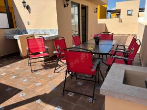 a patio with red chairs and a table on a balcony at Jardines in San Miguel de Allende