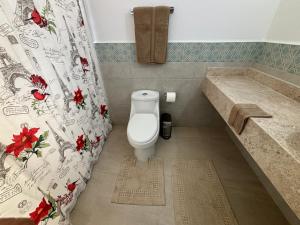 a bathroom with a toilet and a shower curtain at Jardines in San Miguel de Allende +12 photos
