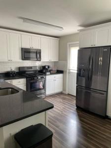 a kitchen with white cabinets and a stainless steel refrigerator at Perfect Lehigh Valley Oasis in Bethlehem