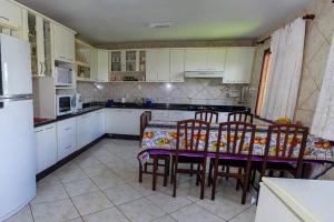 a kitchen with a table and chairs and a refrigerator at Grandhouse Salto Donner in Rio Forcação