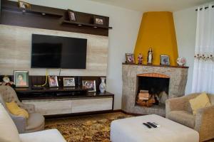 a living room with a fireplace and a flat screen tv at Grandhouse Salto Donner in Rio Forcação