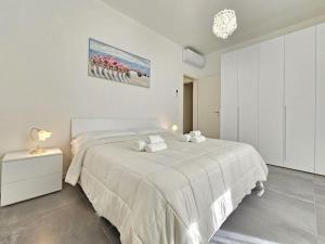 a white bedroom with a bed and a night stand at Elegante a due passi dal centro in Rapallo