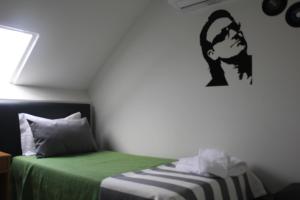 a bedroom with a bed with a green blanket at Guest House Porto Clerigus in Porto