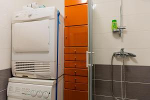 a shower in a bathroom with orange cabinets at Flex SelfCheckIns 120 - Zagreb - Studio Apartment - Loggia in Zagreb