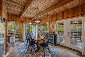 a dining room with a wooden table and chairs at River Song Retreat - Right on the River! in Great Cacapon