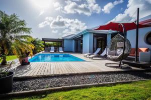 a backyard with a swimming pool and a house at Kisara, Villa moderne 6 pers Piscine in Saint-François