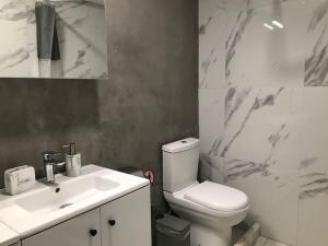 a bathroom with a white toilet and a sink at The Central Retreat 1 in Mytilini +10 photos