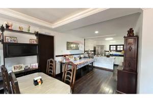 a dining room with a table and a kitchen at Casa Indaiá in Petrópolis