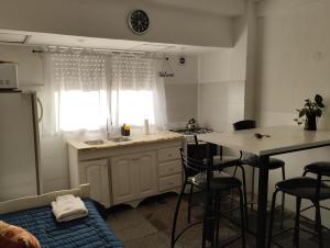 a kitchen with a sink and a table with stools at AmaNi Tigre 2 in Bancalari