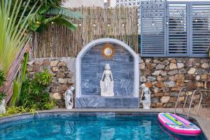 头顿Sun Villa 33 Phan Huy Ích - Phòng Khách Có Máy Lạnh的建筑物旁有一个小水池，水池边有一座雕像。