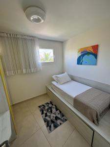 a small bedroom with a bed and a window at Tamoa Residence na Praia de Carneiros Flat 306 in Tamandaré