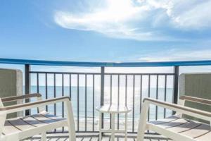 a balcony with two chairs and a view of the ocean at Endless Ocean View Beachfront 1131 in Myrtle Beach +50 photos