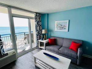 a living room with a couch and a view of the ocean at Endless Ocean View Beachfront 1131 in Myrtle Beach