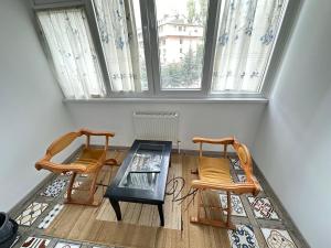 two chairs and a table in a room with a window at Diamond home Apartments in Chişinău