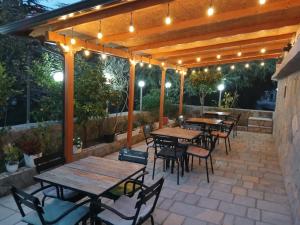 an outdoor patio with tables and chairs and lights at Apartament Qetesia in Çorovodë