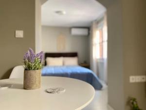 a white table with a vase of purple flowers on it at The Central Retreat 2 in Mytilene