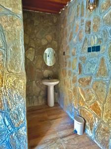 a bathroom with a sink and a stone wall at bait bimah travel lodge in Bīmah