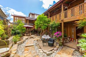 丽江Gucheng Lanshe Designer Garden B&B的带桌椅的户外露台