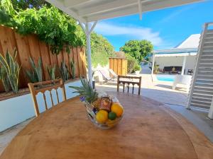 a bowl of fruit sitting on top of a wooden table at Sweet Cane Tiny House & Pool in Saint-François