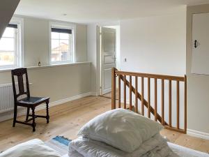 4 star holiday home in GOTLANDS TOFTA في Eskelhem: غرفة نوم بها سرير وكرسي ونوافذ