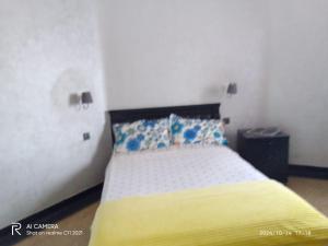 a bedroom with a bed with yellow sheets and blue pillows at North Africa Casablanca in Casablanca
