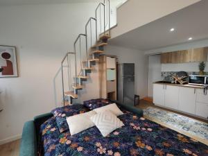 a living room with a bed and a spiral staircase at L'Escapade Cosy 25mn du PuyDuFou in Cholet