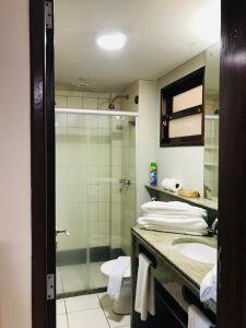 a bathroom with a shower and a toilet and a sink at Flat pé na areia Ponta Negra Natal RN 09 in Natal