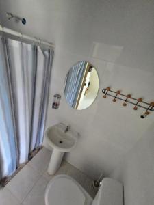 a white bathroom with a sink and a mirror at Habitación en Casa Las Palmitas in Penonomé