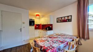 a room with a table and a kitchen with a table and chairs at Résidence Les Pleiades - Appartement spacieux et lumineux · Centre station · Balcon · Parking couvert MAE-7354 in Flaine