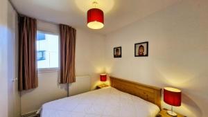 a bedroom with a bed with two lamps and a window at Résidence Les Pleiades - Appartement spacieux et lumineux · Centre station · Balcon · Parking couvert MAE-7354 in Flaine