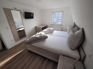 ein Schlafzimmer mit einem großen Bett mit einem Spiegel und einem Spiegel in der Unterkunft Hotel Delphi in Heidenheim