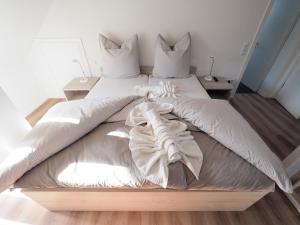 ein großes Bett mit weißen Laken und Kissen in der Unterkunft Hotel Delphi in Heidenheim